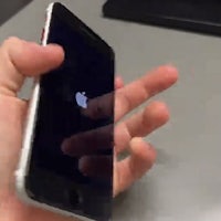 a person is holding up an iphone with a black screen