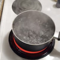 a pot of boiling water on a stove top