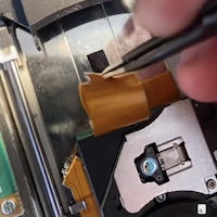 a person is removing a piece of tape from a camera