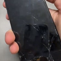 a person holding an iphone with a broken screen